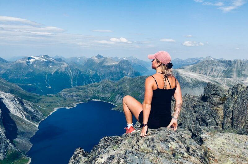 woman sitting on mountain cliff