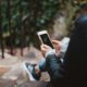 person holding white smartphone sitting on stair