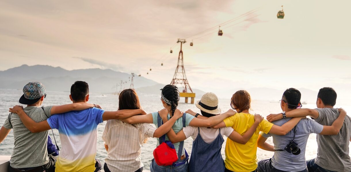 people holding shoulders sitting on wall