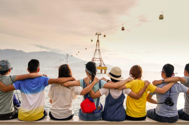 people holding shoulders sitting on wall