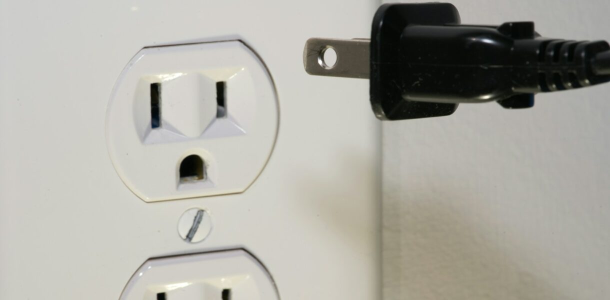 black male plug in front of electric socket