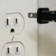 black male plug in front of electric socket