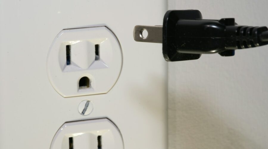 black male plug in front of electric socket