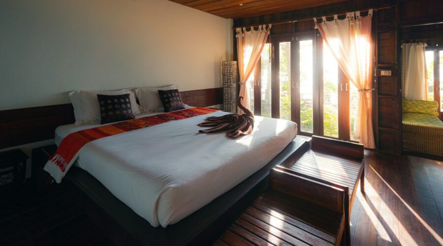 white bed linen near brown window curtain