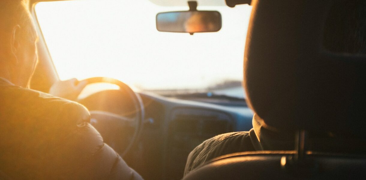 man driving car during golden hour