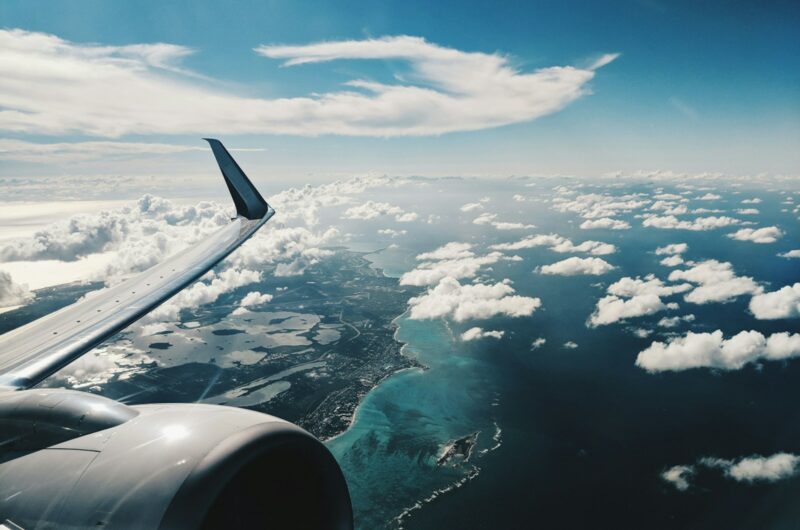 photo of airplane wing under blue sky at daytime