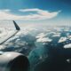 photo of airplane wing under blue sky at daytime