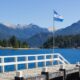 white and blue flag on wooden dock near body of water during daytime