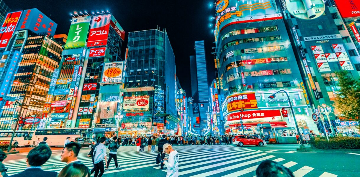 people crossing pedestrian near buildings at night