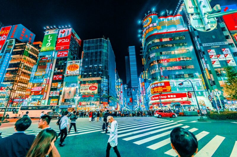 people crossing pedestrian near buildings at night