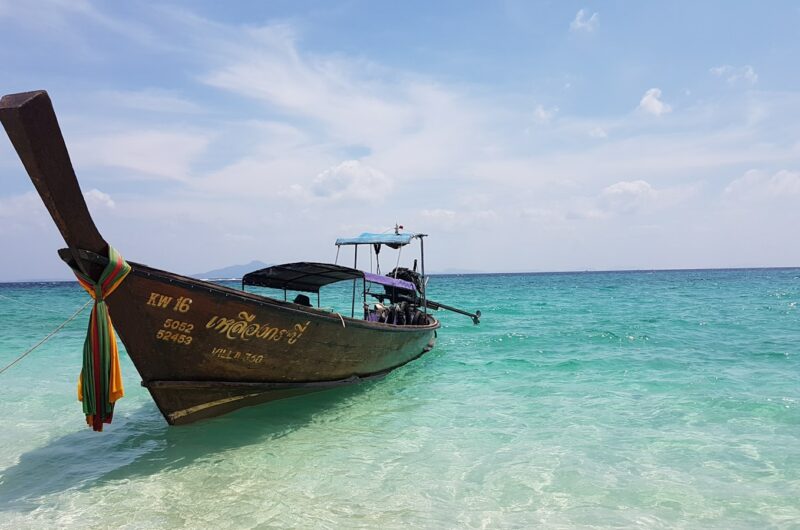 brown and white boat on sea under blue sky during daytime