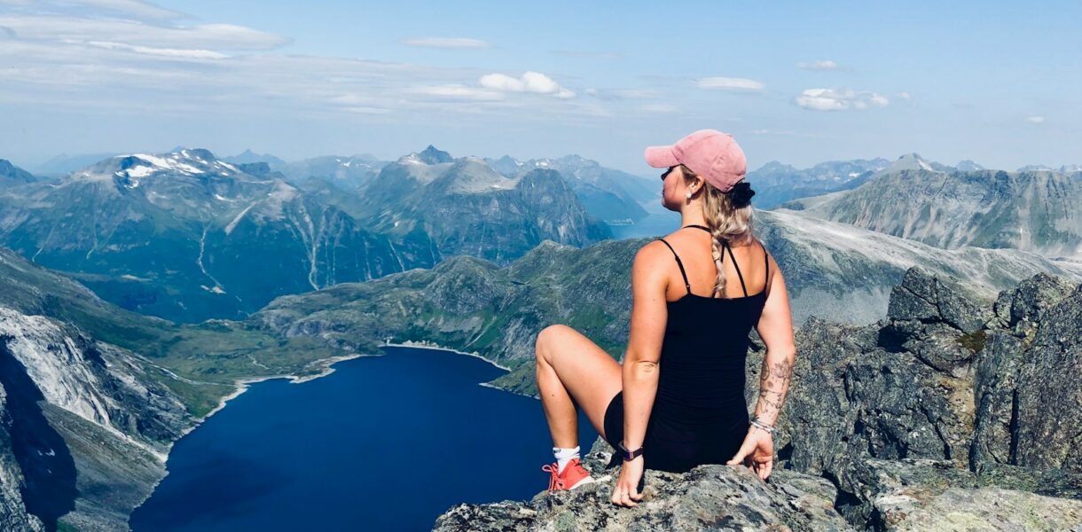 woman sitting on mountain cliff