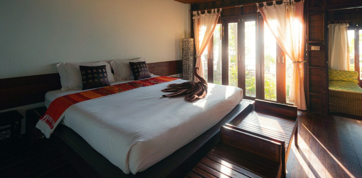 white bed linen near brown window curtain